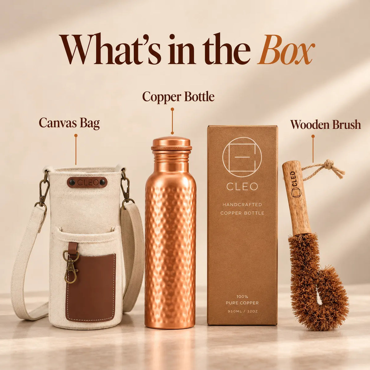 CLEO gift set with a copper bottle, canvas bag, wooden brush, and product box, labeled 'What's in the Box' on a warm beige background.